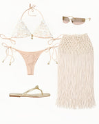 Beach-themed outfit with bikini, skirt, sandals, and sunglasses on a white background